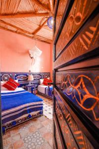 1 Schlafzimmer mit 2 Betten und einer Wand mit Graffiti in der Unterkunft Villa jamal essaouira in Essaouira