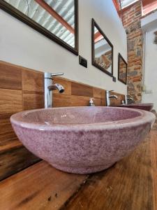 a bathroom with a large purple sink on a wooden floor at Central Hostel San Sebastian in Antigua Guatemala