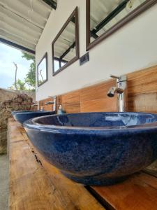 a bathroom with three blue sinks on a wooden counter at Central Hostel San Sebastian in Antigua Guatemala