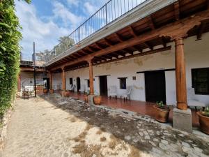een gebouw met een patio met tafels en stoelen bij Central Hostel San Sebastian in Antigua Guatemala