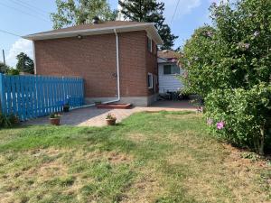a brick house with a blue fence and a yard at Great family choice in Whitby