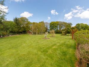 a lawn with a tree in the middle of it at Cherrygarth Cottage in White Hall