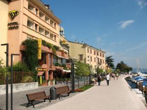 people walking down a sidewalk next to a building at Hotel Vigna in Salò