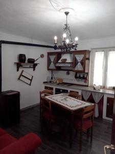 ein Esszimmer mit einem Tisch und eine Küche mit einem Kronleuchter in der Unterkunft La tana di Pisolo in Vicoforte