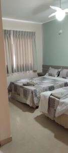 1 dormitorio blanco con 2 camas y ventana en Pousada João & Maria, en Santa Maria Madalena