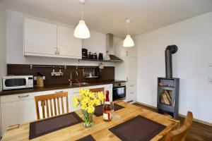 a kitchen with a table with yellow flowers and a stove at Ferienwohnung1 in der Villa Westwind in Thiessow