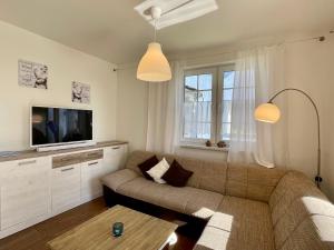 a living room with a couch and a tv at Ferienwohnung1 in der Villa Westwind in Thiessow