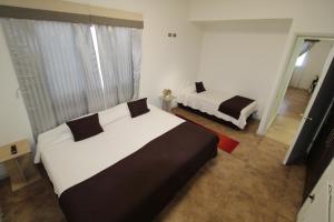 1 dormitorio con 2 camas en una habitación con ventana en Atankalama, en Calama