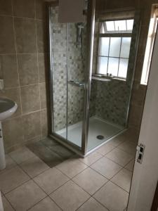 a shower with a glass door in a bathroom at Doonhill Lodge in Galway