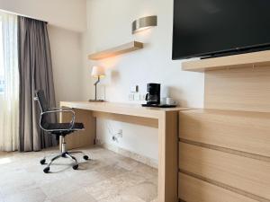a hotel room with a desk and a chair at Courtyard by Marriott Villahermosa Tabasco in Villahermosa