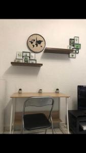 a desk with a chair and a clock on a wall at « Le petit Bastille»Proche Lyon centre in Villeurbanne