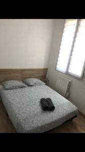 a bedroom with a bed with a pair of shoes on it at « Le petit Bastille»Proche Lyon centre in Villeurbanne
