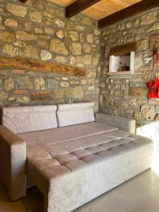 a bed in a room with a stone wall at Bujtina Salko in Muçaj