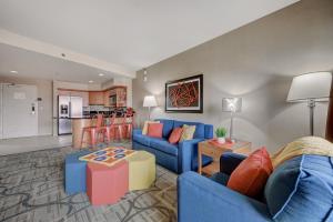 a living room with blue couches and a kitchen at Spacious Retro 1 BR Condo with Sphere Views 1 Block from Vegas Strip NO Resort Fees in Las Vegas