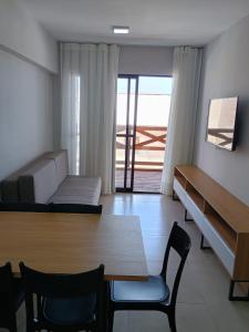 - un salon avec un canapé, une table et des chaises dans l'établissement Vila Atlântida APT 301-B Master, à Luis Correia