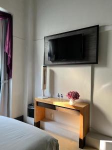 a bedroom with a bed and a tv on a wall at Hotel Alhaja in Puebla