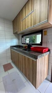 a kitchen with a counter with a red sink at Flat Villa Monte Castelo in Bezerros
