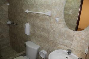 a bathroom with a toilet and a mirror and a sink at COPACABANA in Lima