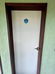 a white door with a blue sign on it at Flat Villa Monte Castelo in Bezerros
