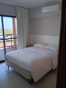 1 dormitorio con 1 cama y puerta corredera de cristal en Vila Atlântida APT 301-B Master en Luis Correia