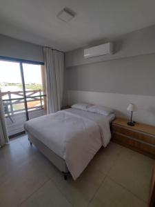 een slaapkamer met een groot bed en een raam bij Vila Atlântida APT 301-B Master in Luis Correia