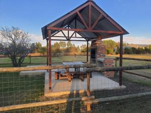a picnic shelter with a picnic table in a field at Holiday Flat at Vaaldam Sgt Pepper's in Oranjeville
