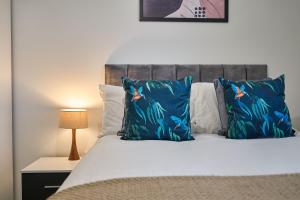 a bedroom with a bed with blue pillows at Host & Stay - 23 Waterside Place in Taunton