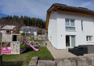 Casa blanca con parque infantil y tobogán en Ferienwohnung Albliebe en Meßstetten
