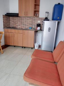 a kitchen with a red couch and a refrigerator at LA MESA CUND, APTO CONJUNTO GETSEMANI in La Mesa