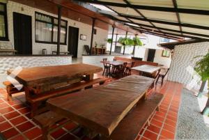 d'une terrasse avec des tables et des chaises en bois dans un restaurant. dans l'établissement FINCA EL ZAFIRO, à Circasia