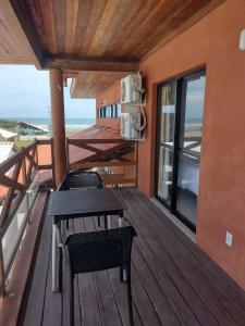 terraza con mesa y sillas en el balcón en Vila Atlântida APT 301-B Master en Luis Correia
