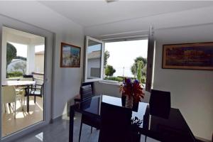 a dining room with a table and chairs and a window at Apartment Marina in Petrcane