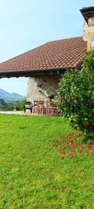 a building with a bench in a grass field at Prau del Urogallo in Ribadesella