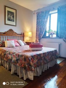 a bedroom with a large bed with blue curtains at Prau del Urogallo in Ribadesella