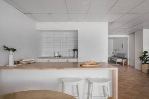 a kitchen with a counter and stools in a room at The Ace - Byron Bay in Byron Bay