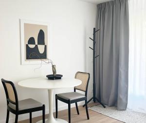 a white table and chairs in a room with a table and a window at Anflor studio in Zwijndrecht