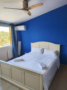 a blue bedroom with a large bed with a blue wall at L'Olivera Casa Rural in Castellbisbal