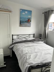 1 cama en un dormitorio con una pintura en la pared en S and S Chalets - 2 - Mablethorpe en Mablethorpe