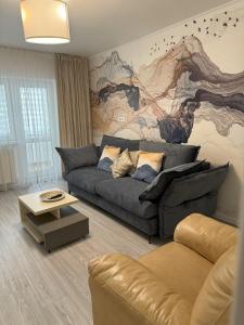 un soggiorno con divano e un grande murale di Imedio Velvet Apartment Aviatiei a Bucarest