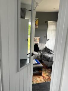 S and S Chalets - 2 - Mablethorpe في مابليتورب: باب يؤدي إلى غرفة معيشة مع أريكة