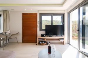 een woonkamer met een flatscreen-tv op een tafel bij Glaros Casa Verde - Cozy flat with Garden near Beach in Kato Daratso