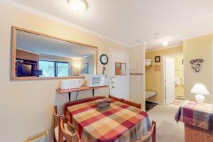 a small room with a table and a kitchen at Snow Ghost Inn 326 in Big White +39 photos