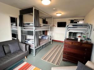 ein Wohnzimmer mit Etagenbetten und einem Sofa in der Unterkunft Lands End Hostel and B&B in Sennen