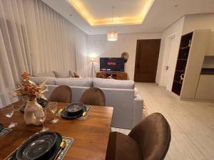 Zaya luxury apartment في الرياض: غرفة معيشة مع أريكة وطاولة