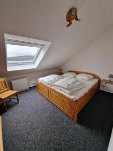 1 dormitorio con cama de madera y ventana en Ferienwohnung Engelsblick, en Winterberg