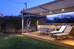 カト・ダラトソにあるGlaros Casa Verde - Cozy flat with Garden near Beachの木製デッキ(テーブル、椅子、パーゴラ付)