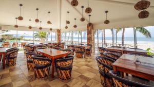 un restaurante con mesas y sillas y el océano en Hotel Bahía Paraíso, en San Blas