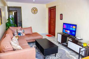 a living room with a couch and a flat screen tv at Raven Suites in Kakamega