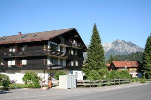 ein großes Gebäude mit einem Berg im Hintergrund in der Unterkunft Sonnenblume in Obermaiselstein