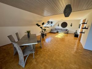 een woonkamer met een tafel en een bank bij Fewo BOHO 110 qm mit Bergblick 3 min Bahnhof in Laufen